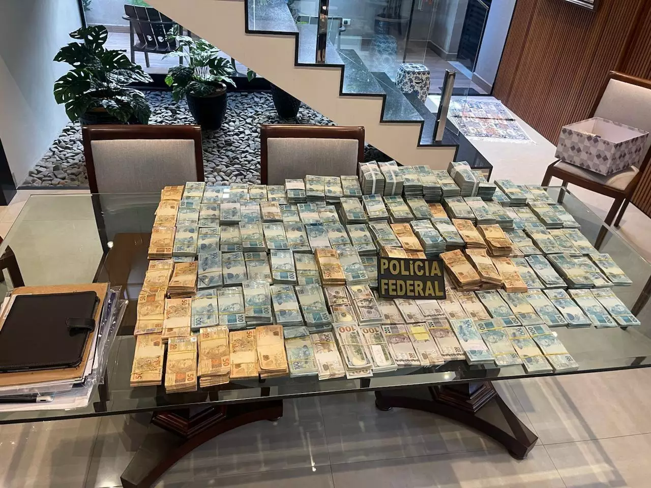 PF apreende 2,7 milhões em reais e dólares na casa de desembargador e armas